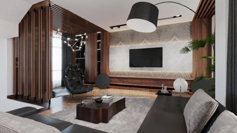 Là một trong những ý tưởng thiết kế nội thất phòng khách biệt thự cao cấp được thiết kế theo lối hiện đại nhưng lại sử dụng chất liệu gỗ làm chủ đạo đã tạo nên vẻ đẹp độc đáo, mới lạ trong Vinhomes Imperia Hải Phòng. Gỗ được biến hóa đa dạng nhưng lại mang tính liền mạch, từ chất liệu làm kệ trang trí, gỗ ốp tường, tạo điểm nhấn đến kệ trang trí. Tuy nhiên không làm cho không gian bị trầm, bởi sự kết hợp khéo léo khi sử dụng chất liệu đá ốp tường có độ bóng sang cùng gam màu tương phản, kết hợp cùng màu đơn sắc trần thạch cao đã làm không gian như trở thành bức tranh hài hòa nhưng lại cuốn hút không ngờ. Thiết kế nội thất phòng khách
